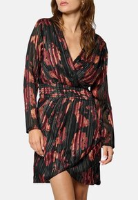 Robe noire à manches longues, avec un décolleté en V profond, un motif floral rouge et or, une texture plissée et une taille cintrée.