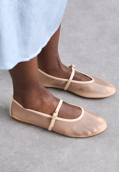 Beige mesh ballet flats with a strap and small buckle detail, featuring a rounded toe and flexible sole.