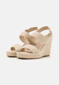 Beige kile-sandaler med vævede tekstilremme, åbent tådesign, justerbar ankelspænde og struktureret espadrille-sål.