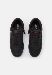 Sapatilhas atléticas pretas com material em malha, acabamento texturizado, detalhes em vermelho e um design com atacadores. Apresenta um logótipo na palmilha e na lateral.
