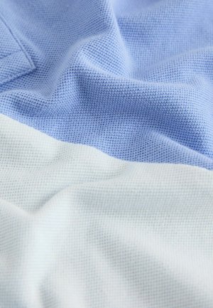Light blue and white textured fabric, featuring a woven pattern with a soft, smooth finish and gentle drape, displaying subtle gradient transitions.