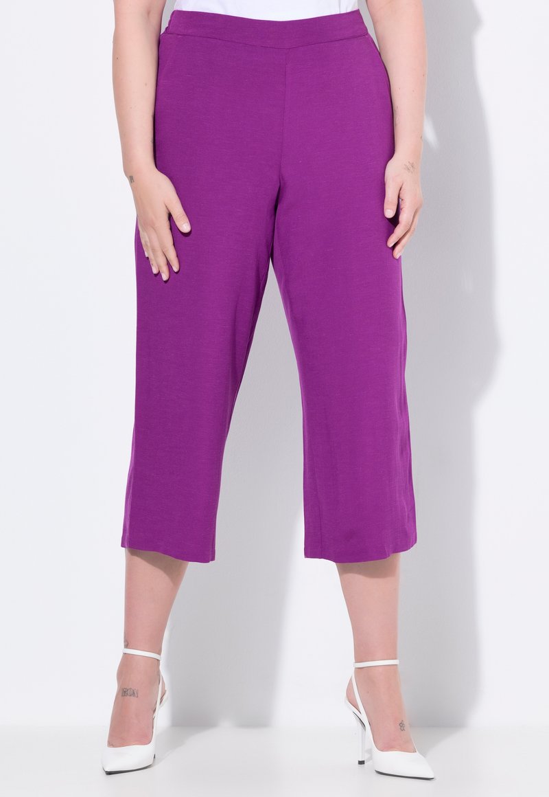 Pantalones cortos morados hechos de un material suave con una textura lisa, que cuentan con una cinturilla ancha y un corte de pierna recta.