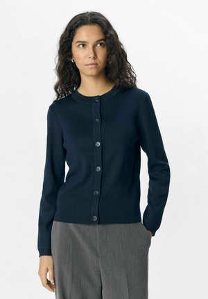 Mörkblå cardigan med långa ärmar, rund halsringning och knappstängning framtill. Ribbtextur och fem matchande knappar längs stängningen.