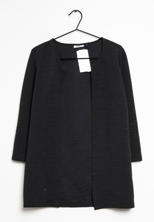 Cardigan noir à côtes avec un col rond et une ouverture sur le devant. Dispose de manches longues et d'une doublure intérieure lisse. Suspendu sur un crochet noir.