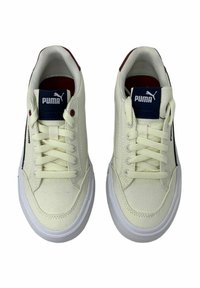 Sneaker in tela crema con suola in gomma bianca, caratterizzate da dettagli in blu navy e un logo sulla linguetta, e lacci piatti per una calzata sicura.
