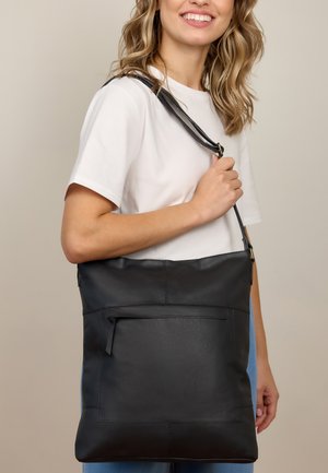 Schwarze Leder-Tragetasche mit verstellbarem Tragegurt, ausgestattet mit einem Front-Reißverschlussfach und glatter Oberfläche. Einfaches rechteckiges Design.