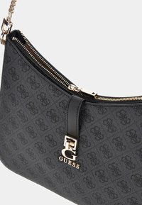 Borsa a tracolla nera in tessuto con chiusura a zip. Presenta un accento in hardware dorato e un dettaglio del logo impresso sulla parte anteriore.