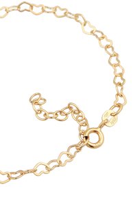 Guldpläterat kedjearmband med hjärtformade länkar och ett runt spänne, med en stämpel som visar metallens kvalitet.