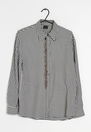 Black and white gingham check long-sleeve shirt with a collar and button-down front. Features a chain accent along the placket.