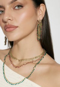 Goldschmuckset mit geschichteten Halsketten, die aus türkisfarbenen, grünen und pinken Perlen bestehen. Schwingende Ohrringe im Chandelier-Stil passen zu dem Design der Halskette.