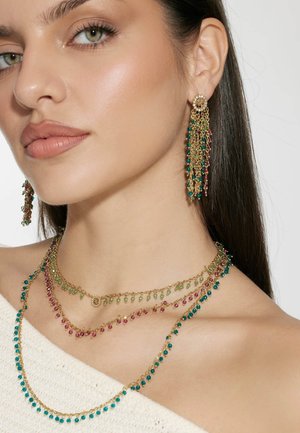 Goldschmuckset mit geschichteten Halsketten, die aus türkisfarbenen, grünen und pinken Perlen bestehen. Schwingende Ohrringe im Chandelier-Stil passen zu dem Design der Halskette.