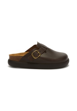 Bruna läder slip-on klackar med justerbar guldspänne och svart sula, med en konturerad korkfotbotten synlig inuti.