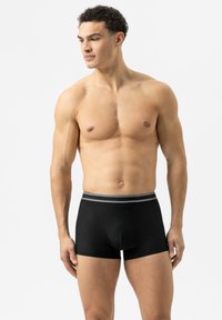 Boxers noirs côtelés avec une taille grise, offrant une coupe ajustée et une texture lisse. Aucun logo ou motif visible.