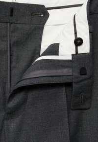 Pantaloni negri croiți, cu o textură netedă, având o căptușeală albă, închidere cu fermoar și accente contrastante din țesătură gri.