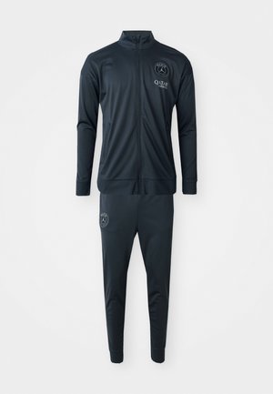 Dark navy tracksuit with a zip-up jacket and tapered pants. Features an embroidered logo on the jacket and pants. Made from smooth, lightweight fabric.