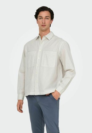 Long-sleeve button-up shirt in light cream with thin vertical stripes, featuring two chest pockets and a relaxed fit. Soft cotton blend fabric.
