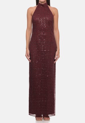 Vestido halter burdeos sin mangas y largo con patrón de rejilla brillante, usado por una persona de pie con las manos relajadas a los lados.