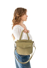 Olivovo zelená nylonová kabelka s krátkymi ušami a odnímateľným ramenným popruhom, s predným vreckom a jemným logom značky.