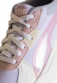 Sneaker PUMA con tomaia in rete color lavanda e dettagli rosa, lacci bianchi e un design a strisce rosa lucido lungo il lato.