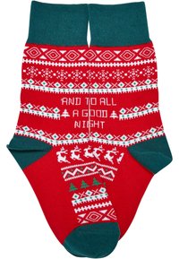 Röda julsockor med gröna muddler, stickade mönster av träd, renar och snöflingor, med texten "OCH TILL ALLA EN GOD NATT."