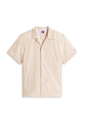 Beežika lühikeste varrukatega särk, millel on krae ja kogu pinnal ringikujuline augumuster ning vasakul varrukal väike logo.