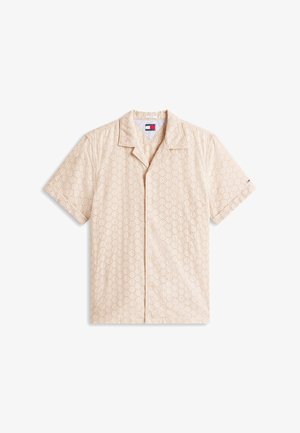 Beežika lühikeste varrukatega särk, millel on krae ja kogu pinnal ringikujuline augumuster ning vasakul varrukal väike logo.