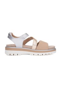 Flade sandaler med en blanding af materialer: sølv, metalisk og beige ruskindstropper. Hvid, struktureret sål med lysebrune accenter.