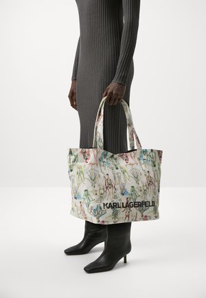 Geantă tip tote cu ilustrații de modă colorate pe un material texturat; are mânere robuste și un logo negru la bază.
