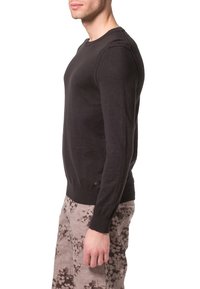 Suéter negro de manga larga con puños y dobladillo acanalados, fabricado en una tela suave, con un escote redondo y detalles de costura sutiles.