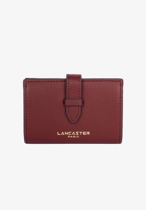 Portafoglio in pelle bordeaux con finitura texture, dotato di un risvolto anteriore fissato da una tracolla e del logo in oro stampato "LANCASTER PARIS".