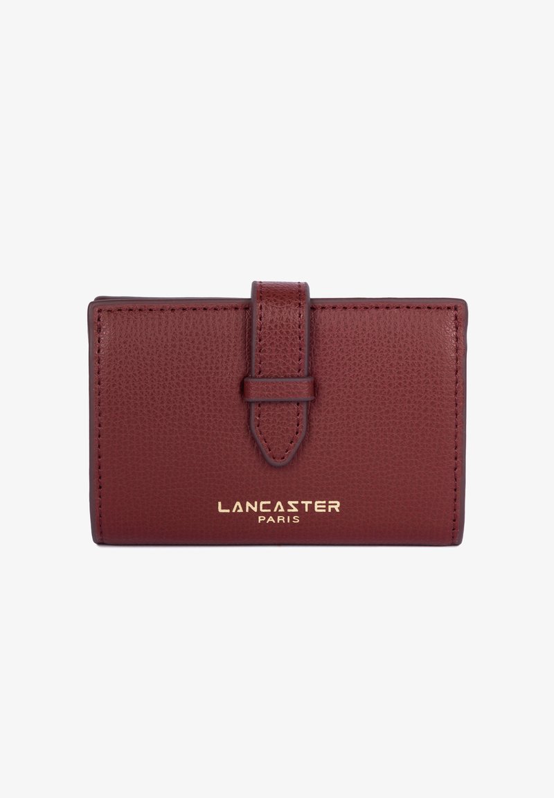 Portafoglio in pelle bordeaux con finitura texture, dotato di un risvolto anteriore fissato da una tracolla e del logo in oro stampato "LANCASTER PARIS".