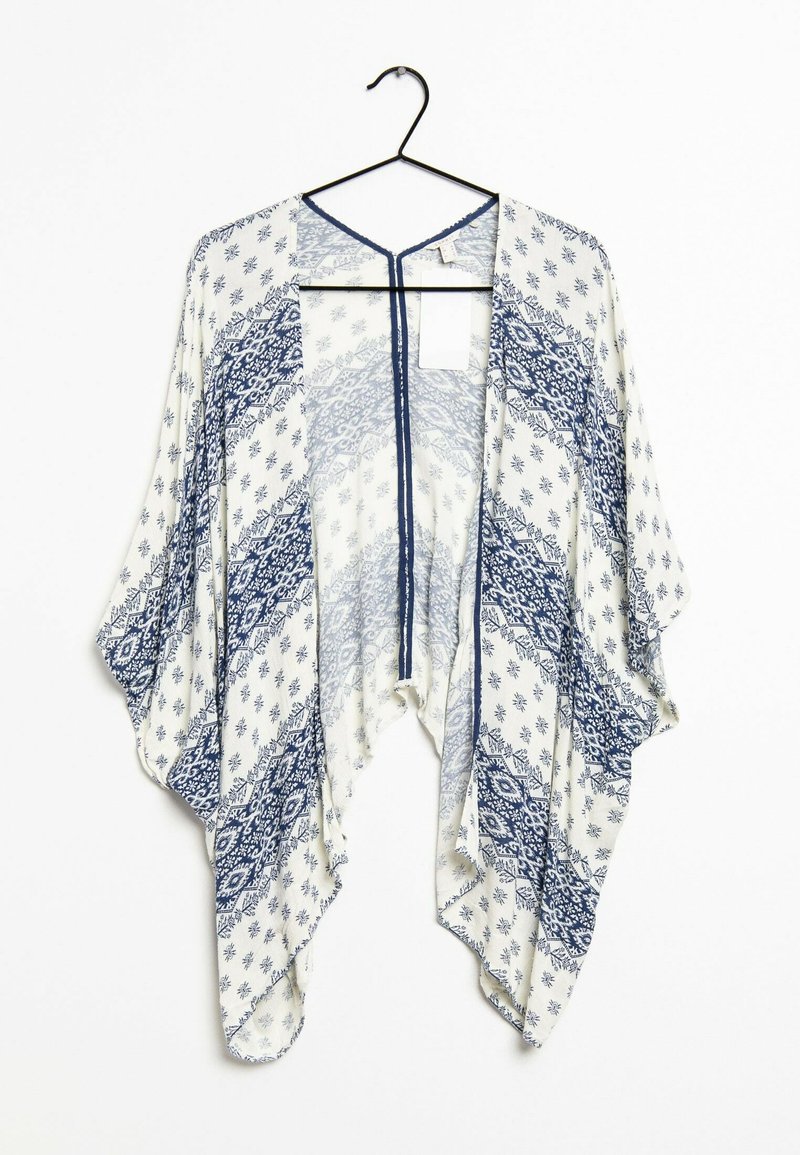 Kimono leggero in crema con motivi geometrici blu navy, con apertura davanti, maniche larghe e una vestibilità ampia; appeso a un gancio nero.