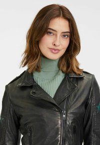 Veste de moto en cuir noir avec fermeture éclair, col et texture plissée, ornée d'étoiles vertes sur les manches.