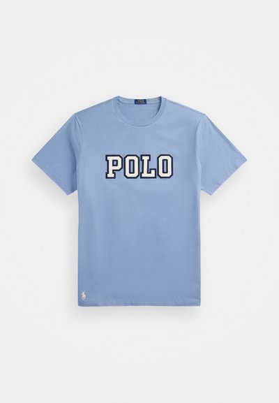 Világoskék pamut póló kerek nyakkivágással, nagy fehér és sötétkék "POLO" logóval, a szegélyén pedig egy kisebb logó részlettel.