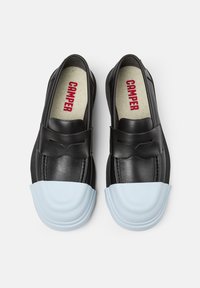 Černé kožené slip-on boty s modrou gumovou špičkou. Mají hladký design a jemný mašlový akcent na přední straně.