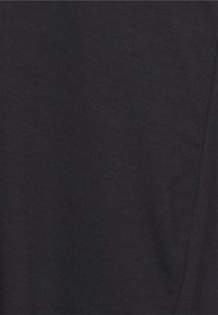 Close-up de tecido de uma t-shirt preta, apresentando uma textura suave com ligeira elasticidade. Design simples, sem padrões ou acessórios visíveis.