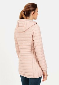Veste rose rembourrée avec une silhouette ajustée, capuche et détails de couture verticale. Elle présente des poignets côtelés, une texture douce et un design mi-long.