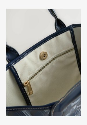 Sötétkék táska texturált mintával, arany színű cipzárzárral és belső zsebbel. Világos bézs színű bélés szövetből, varrási részletekkel.
