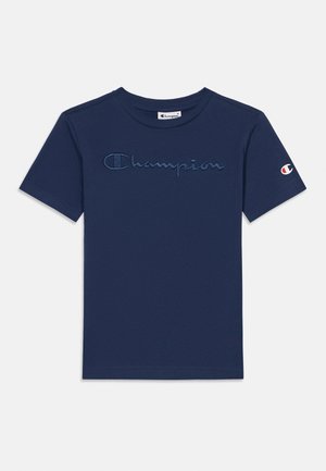 Tumesinine puuvillane T-särk, millel on lühikesed varrukad ja rinnal tikitud "Champion" logo, varrukal detailne logo.