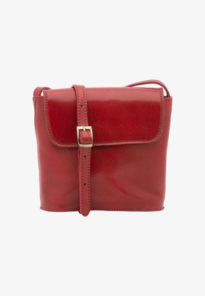 Sac bandoulière en cuir rouge avec un rabat avant sécurisé par une lanière cousue et une boucle argentée.