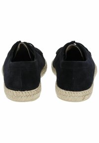 Espadrilles de ante negro con suela envuelta en yute, detalle en la parte trasera que presenta una pequeña apertura y acentos de costura. Diseño casual sin cordones.