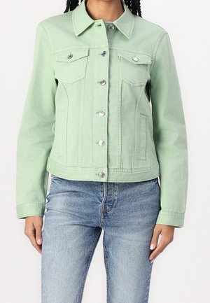 Mintgrøn denimjakke med sølvhardware, to brystlommer og krave, parret med lyseblå jeans.