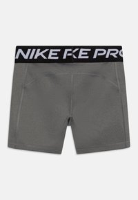 Szürke sportnadrág fekete elasztikus derékpánttal, amelyen fehér "NIKE PRO" logó található. Simával és illeszkedő kialakítással, varrási részletekkel.