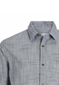Camicia grigia con bottoni in un tessuto testurizzato caratterizzato da un motivo a scacchi sottile. Ha un colletto classico e bottoni in legno.