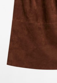 Braunes Wildleder mit einer weichen Textur und leichtem Glanz, ausgestattet mit einem glatten Saum und minimalen Nähten.