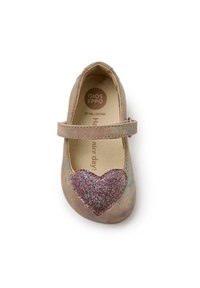 Scarpa per bambini in pelle piena di colore beige chiaro con un accento a forma di cuore glitterato. Presenta una chiusura con strap e un design a punta tonda. Suola piatta.
