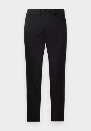 Chino noirs en tissu lisse avec une coupe droite. Comprend une fermeture à bouton à l'avant et des poches latérales avec un design épuré et minimal.