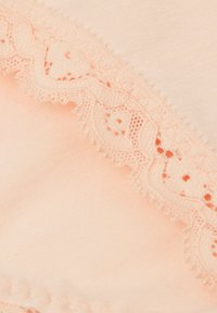 Pfirsichfarbener Stoff mit einer zarten Spitzenborte, die komplizierte Muster und gewellte Kanten aufweist und eine weiche Textur sowie ein nahtloses Design hervorhebt.