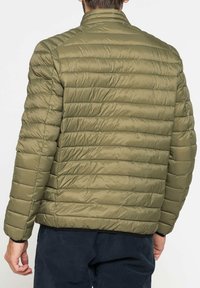 Giacca imbottita verde oliva con motivo a righe orizzontali, colletto alto e maniche lunghe. Il materiale sembra liscio e lucente.