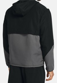 Czarna i szara kurtka z kapturem o wielokolorowym wzorze. Lekki materiał, gładka tekstura i luźny krój. Zawiera częściowy zamek błyskawiczny.